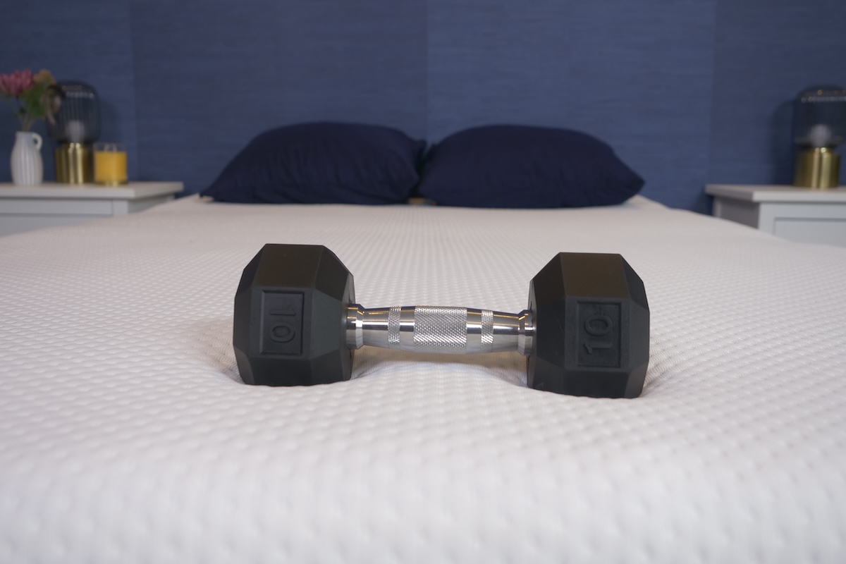 A 10-pound weight sits on top of an Emma mattress in our testing facility