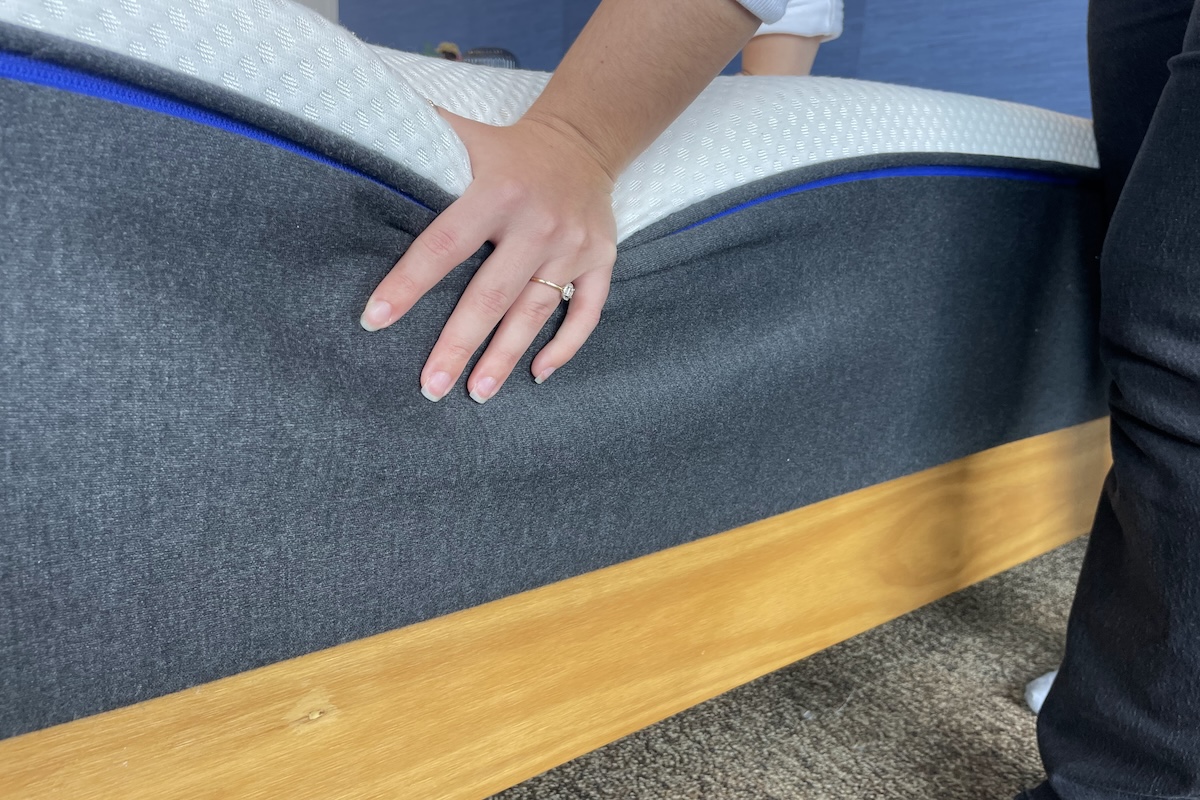 Our tester pushing down on a Nectar mattress to test firmness and edge support